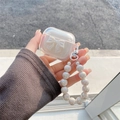 Detail der AirPods Hülle mit weißer Schleife und schillernder Perlen-Handschlaufe - 1./2. Gen Universal / Transparent Weiß Schleife (Weiße Perlenkette)