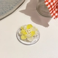 Detalle macro de un soporte de móvil de flor 3D con perla y pétalos degradados en amarillo - Modelo Magnético / Blanco Ámbar