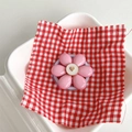 Close-up of pink flower magnetic phone holder with a gold heart center on checkered cloth - Magnetic Pink