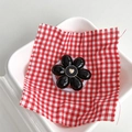 Detail view of a black flower phone socket with a gold heart on a red checkered cloth - Magnetic Black