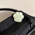 Close-up of translucent mint green cat paw phone grip with heart detail on a black bag - Frosted Cat Paw Stand-Jelly Jasmine Green