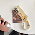 Close-up of yellow leather foldable phone case featuring cute puppy charms and hand strap - Yellow / Samsung ZFlip3