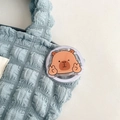 Detail van schattige capibara acryl uitschuifbare telefoonhouder op een getextureerde tas - V-teken Capibara (Nr. 17)