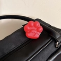 Detail der roten Katzenpfoten-Handyhalterung mit Herzdesign an schwarzer Ledertasche - Mattierte Katzenpfote Ständer-Gelee Rot
