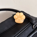 Nahaufnahme der orangefarbenen Katzenpfote-Handyhalterung mit Herz auf einer Tasche - Mattierte Katzenpfote Ständer-Gelee Orange