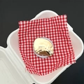 Detail view of gold mirror phone grip with 'happy' engraving on picnic cloth setup - Happy Geometric Glossy Gold