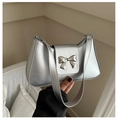 Sac à épaule argenté métallisé avec détail de boucle papillon sur fond blanc - Argenté