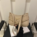 Elegante bolso baguette beige con lazo dorado y correa en un ambiente minimalista - Caqui