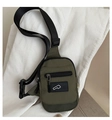 Detalle de la bandolera de nailon verde militar con bolsillo frontal y parche con logo MK - Verde