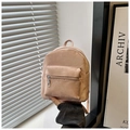 Handheld view of pink mini PU leather backpack featuring front zip pocket and top handle - Pink