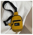 Detalle de riñonera de nailon amarillo con correa ajustable sobre fondo de pana blanca - Amarillo