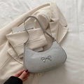 Silver glitter crescent underarm bag with metallic bow detail on beige blazer - Silver