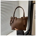 Close-up of brown litchi grain leather bucket bag with gold hardware and dual handles - Coffee