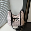 Pale pink bubble textured tote bag with black bow and heart pendant in natural light - Pink