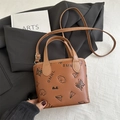 Brown leather bucket bag with playful illustrations and adjustable crossbody strap - No Pendant / Brown