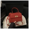 Detailed view of luxury red sequined handbag with gold hardware in a gift box display - Red