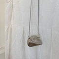 Dettaglio di una mini borsa a conchiglia in metallo argento con texture in rilievo - Argento