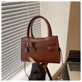 Detailed view of deep brown leather handbag featuring an elegant bow and metal buckle accents - Coffee