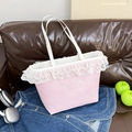 Bolso tote de lona rosa con encaje blanco y bordado sobre sofá de cuero - Rosa