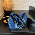 Large dark blue denim tote bag with frayed edges and adjustable strap on books - Light Blue