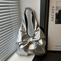 Silberne Schultertasche in Schleifenform mit glänzendem Metallic-Finish und modernem Design - Silber