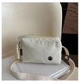 Detail of cream crossbody bag with wide strap and metallic Fanyissa logo branding - White