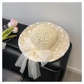 Detail of beige woven straw hat with white lace floral embroidery and tulle bow - Beige / Hat
