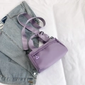 Light purple nylon crossbody bag with adjustable wide strap on casual denim jacket background - Purple