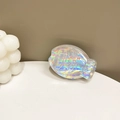 Detailed holographic fish-shaped phone grip with scales and fins on a white platform - Adhesive Silver Laser Fish Stand (Transparent)