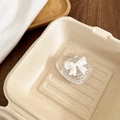 Close-up of clear heart-shaped phone grip with 3D white bow tie on a rustic tray - Style 2 White Bowknot