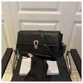 Detailopname van zwarte getextureerde leren handtas met elegante gouden gesp - Zwart