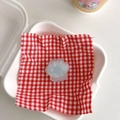 Detail of translucent cat paw phone grip with matte texture on red checkered fabric - Green Core