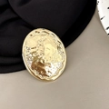 Detailed close-up of golden oval phone holder with textured hammer-pattern finish - Oval Shape - Shiny Gold