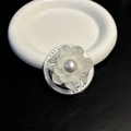 Detalle del soporte de móvil de flor de perla con bordes plateados sobre cuero - Blanco
