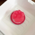 Macro shot of 3D pink cat paw magnetic phone grip with heart detail on a red base - Matte Cat Paw - Rose Red
