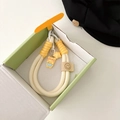 Detail of woven phone lanyard with cartoon bear and star pendants in a gift box - Star Apron Yellow Bear