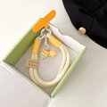 Detailed macro view of woven cream lanyard with star and bear charms in gift box - Star Ice Cream Yellow Bear