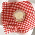 Detail view of a cat paw phone socket on red checkered fabric with Good Luck text - Yellow