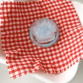 Detail of cute transparent cat paw phone socket with blue Good Luck base on plaid fabric - Blue