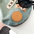 Detail of light blue denim phone grip with cute bear embroidery and brown leather patch - Golden Brown