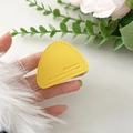 Close-up of yellow triangle leather phone stand with mountain engraving and stitched edges - Yellow