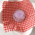 Detail of lavender cat paw phone socket with heart accent on red checkered cloth - Purple
