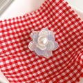 Close-up of pearl flower phone grip with iridescent petals on a checkered cloth background - Blue & White