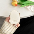 Detail of mango-shaped cream leather phone grip with delicate embossed text - White