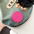 Detail of blue denim accessory with pink button patch and embroidered bear patch - Rose Red