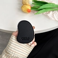 Close-up of black leather mango-shaped phone grip with C'est la vie embossed texture - Black
