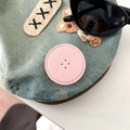 Detailed macro view of denim hat texture with bear embroidery and leather patch - Light Pink