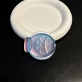 Macro shot of fish-shaped laser phone grip with holographic gradient on black leather - Magnetic / Shiny Blue