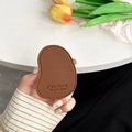 Close-up of brown leather mango-shaped phone grip with litchi texture and gold stamping - Brown