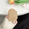 Detail of mango-shaped leather phone socket with stitched edges and engraved text - Khaki